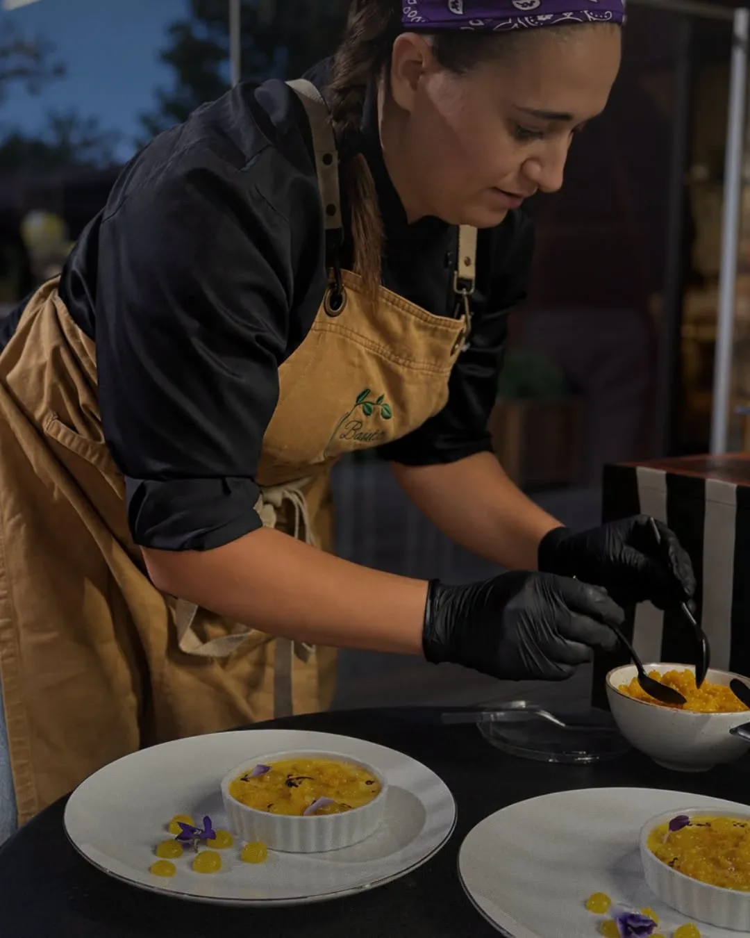 Cozinheira do Basilic a finalizar sobremesas com esferas de manga e flores comestíveis