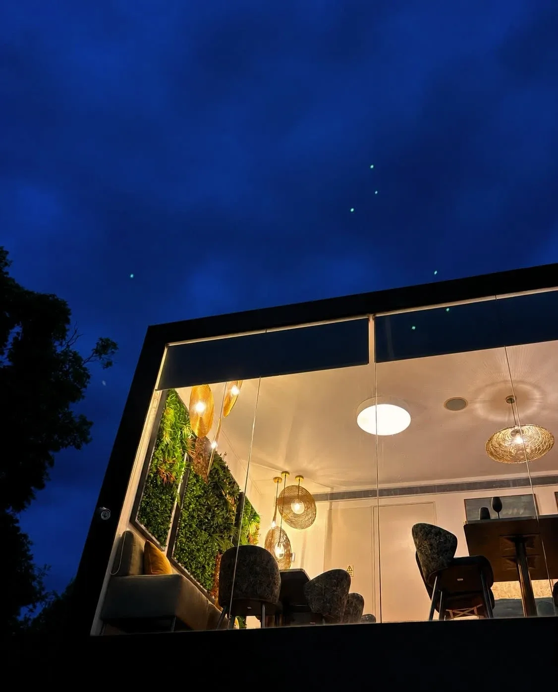 Sala envidraçada do Basilic iluminada ao anoitecer