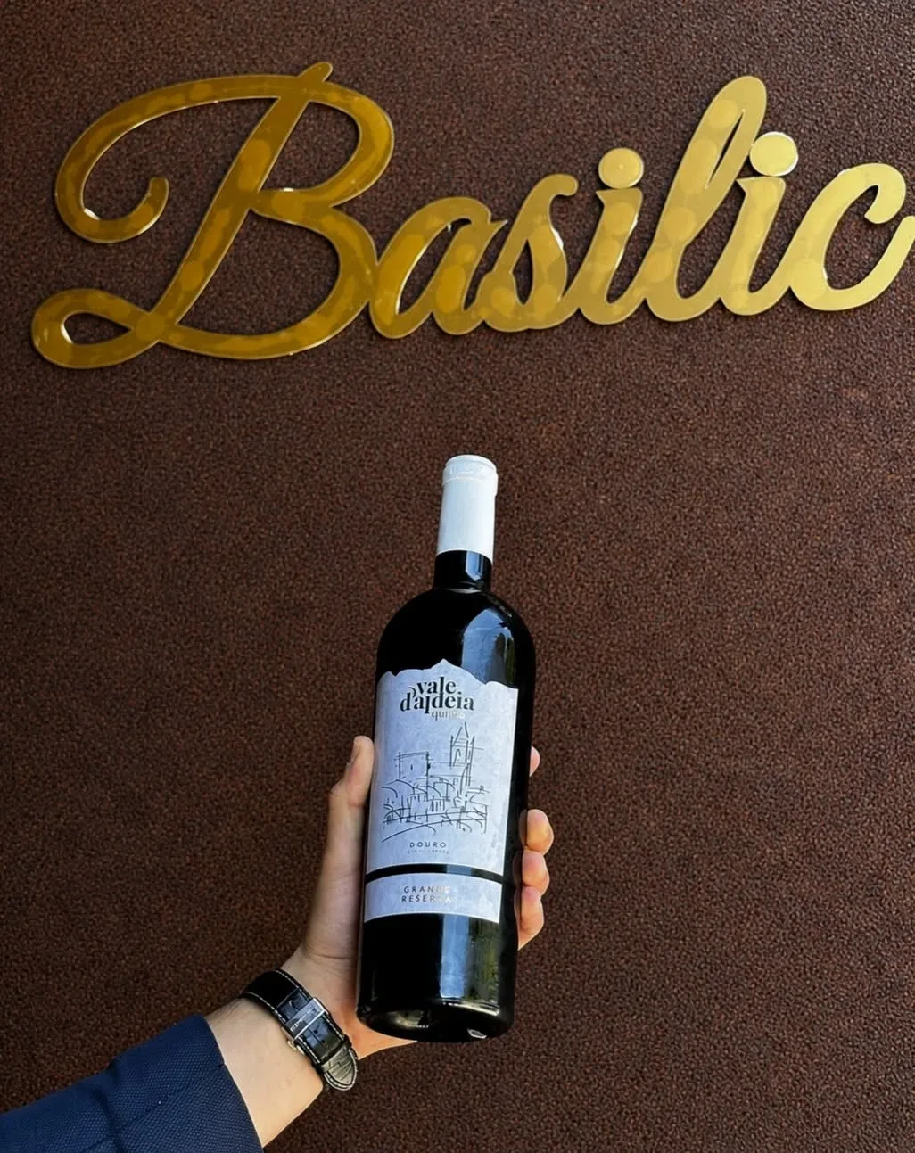 Quinta Vale d'Aldeia Grande Reserva diante do letreiro dourado Basilic
